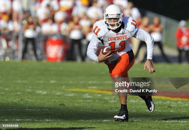 Quarterback Zac Robinson of the Oklahoma State Cowboys scrambles for yards in the first half of play during the game against the Iowa State Cyclones...