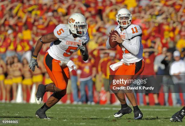Quarterback Zac Robinson of the Oklahoma State Cowboys looks down field as running back Keith Toston runs out of the backfield during the game...