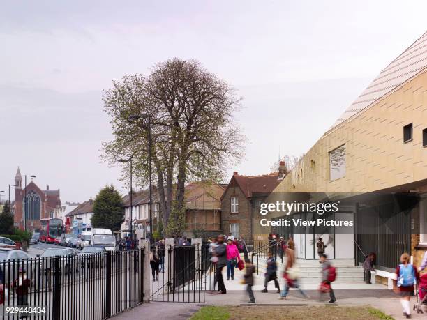 School street side entrance area - with students. Whitehorse Manor Junior School at Pegaus Academy, Thornton Heath, United Kingdom. Architect:...