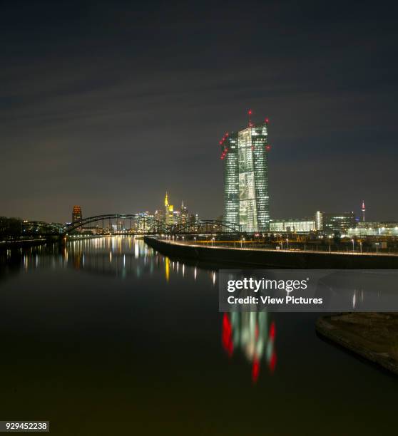 Distant view to the new European Bank Headquarters at night. European Central Bank, Frankfurt, Germany. Architect: coop-himmelblau, 2015.