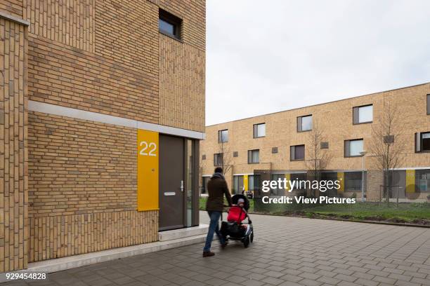 Three-quarter view to apartment 22 and Bart van der Leckplantsoen featuring resident with pram walking by. Middengebied Noord Overtoomse Veld...