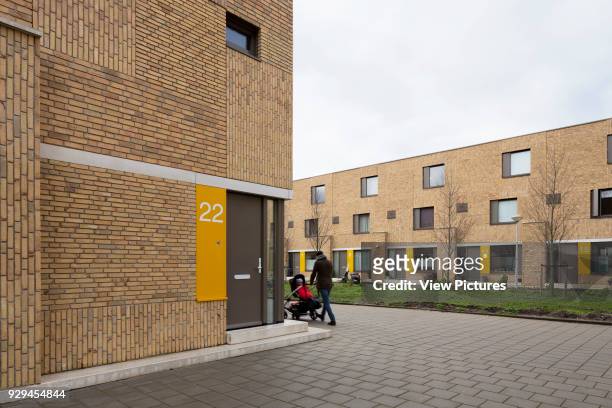 Three-quarter view to apartment 22 and Bart van der Leckplantsoen featuring resident with pram walking by. Middengebied Noord Overtoomse Veld...
