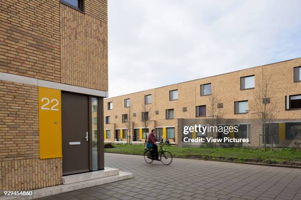 Three-quarter view to apartment 22 and Bart van der Leckplantsoen with cyclist riding by. Middengebied Noord Overtoomse Veld residences, Amsterdam,...