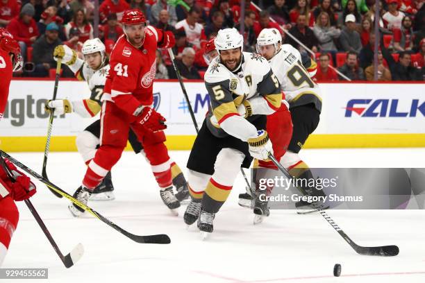 Deryk Engelland of the Vegas Golden Knights tries to control the puck in front of Luke Glendening of the Detroit Red Wings during the second period...