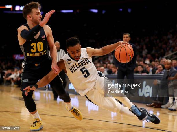Phil Booth of the Villanova Wildcats drives around Andrew Rowsey of the Marquette Golden Eagles in the second half during quarterfinals of the Big...