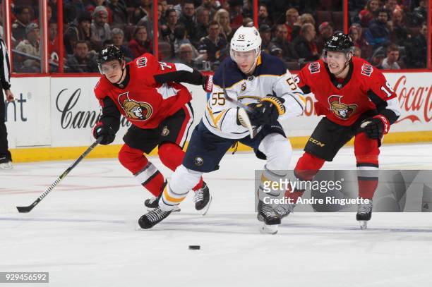 Rasmus Ristolainen of the Buffalo Sabres battles for puck possession against Mark Borowiecki and Ryan Dzingel of the Ottawa Senators at Canadian Tire...