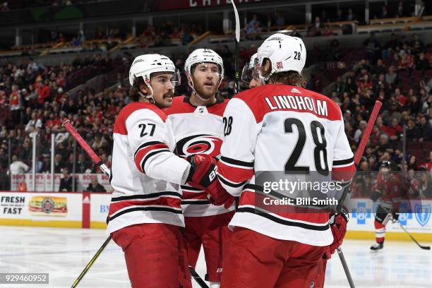 Justin Faulk and Jaccob Slavin of the Carolina Hurricanes celebrate with teammates after the Hurricanes scored against the Chicago Blackhawks in the...