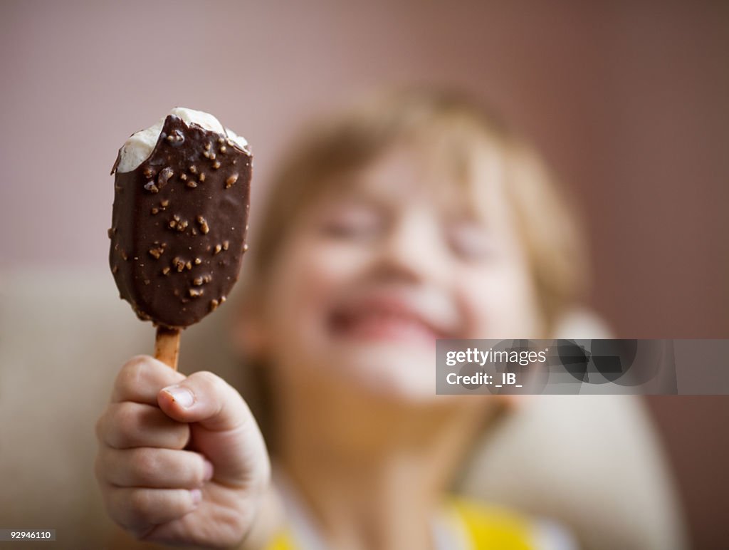 Young boy enjoying a chocolate covered ice cream bar