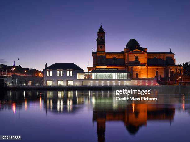 View of exterior across River Shannon at dusk with Athlone Castle in background. Luan Gallery, Athlone, Ireland. Architect: Keith Williams...