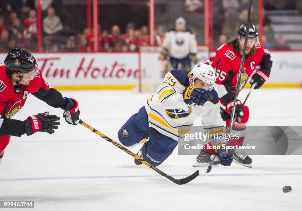 Buffalo Sabres Right Wing Jason Pominville is tripped by Ottawa Senators Right Wing Mark Stone during the first period of the NHL game between the...