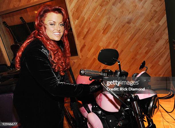 Singer/songwriter Wynonna Judd signs the Pink Harley XL883 Sportster being auctioned to help raise money for breast cancer research through Susan G....