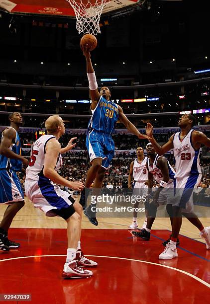 David West of the New Orleans Hornets drives to the basket past Chris Kaman and Marcus Camby of the Los Angeles Clippers in the second half at...
