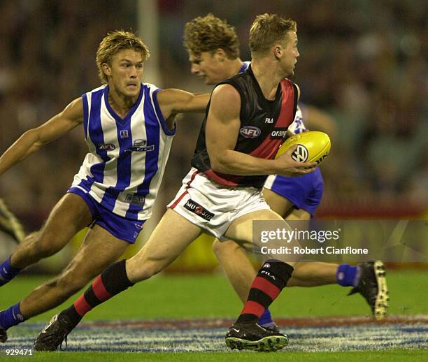 Jason Johnson for the Bombers gets away from Jess Sinclair for the Kangaroos during the match between the Kangaroos and the Essendon Bombers, during...