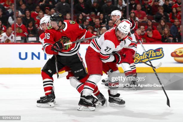 Matthew Highmore of the Chicago Blackhawks and Justin Faulk of the Carolina Hurricanes watch for the puck in the second period at the United Center...