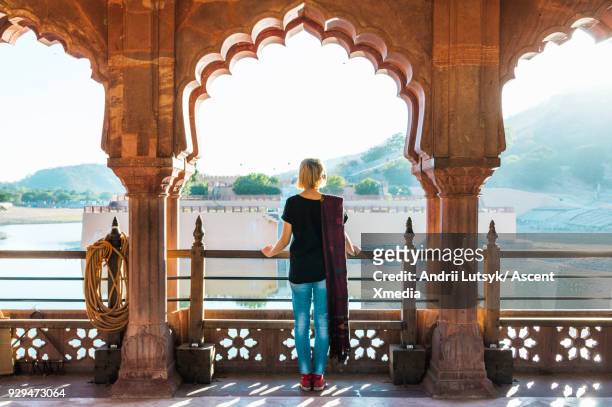 young woman looks out at amer fort in morning light, jaipur - black top stock pictures, royalty-free photos & images