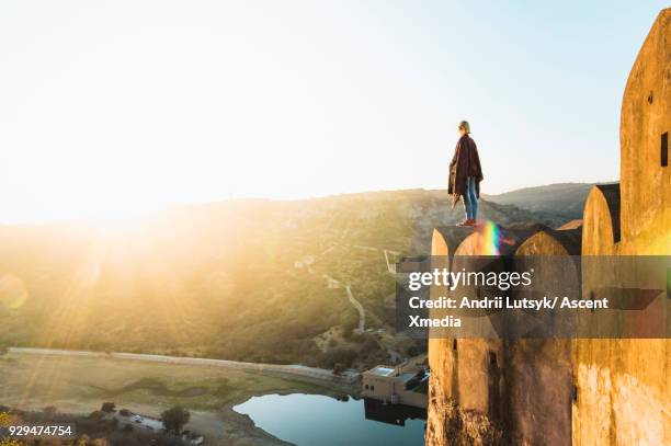 young woman walks on wall in morning light, amer fort in distance, jaipur - same person different looks stock pictures, royalty-free photos & images