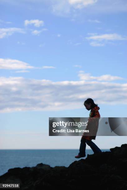 girl stepping on seaside rocks - kiama stock pictures, royalty-free photos & images