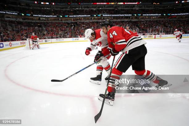 Jan Rutta of the Chicago Blackhawks and Justin Williams of the Carolina Hurricanes skate in the third period at the United Center on March 8, 2018 in...