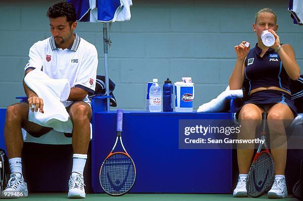 Jelena Dokic and her partner Nenad Zimonjic of Yugoslavia rest between a game in their match against Cara Black and Kevin Ullyett of Zimbabwe, during...