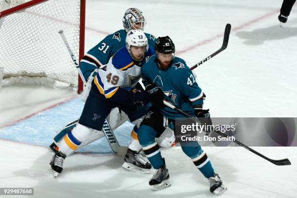 Martin Jones and Joakim Ryan of the San Jose Sharks defend Ivan Barbashev of the St. Louis Blues at SAP Center on March 8, 2018 in San Jose,...