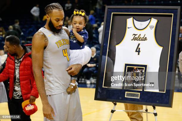 Toledo Rockets guard Tre'Shaun Fletcher holds his daughter while looking at his framed jersey that was presented to him during the senior recognition...