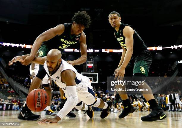 Jevon Carter of the West Virginia Mountaineers dives for a loose ball as Terry Maston of the Baylor Bears defends during the Big 12 Basketball...