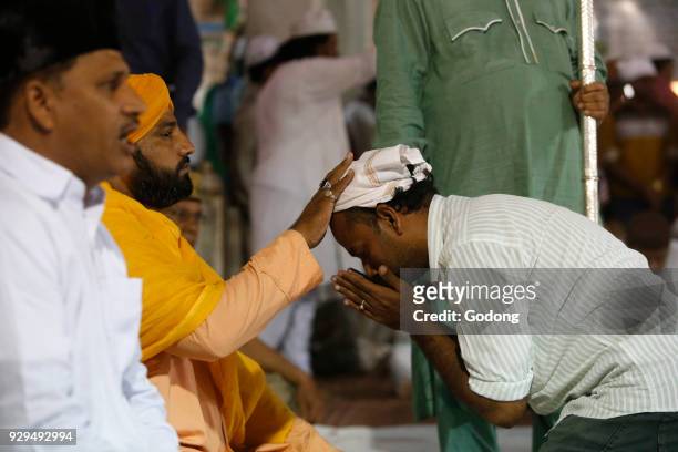 Ajmer Sharif dargah, Rajasthan. Faithful receiving a blessing from Sheikh Syed Zainul Abedin Ali Khan. India.