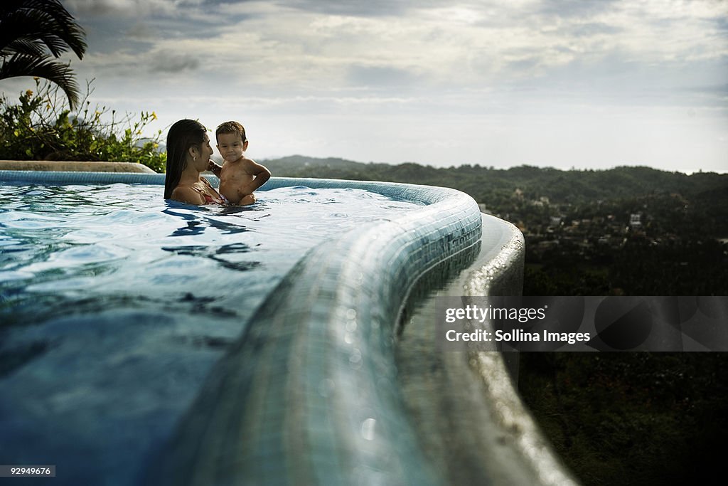 Mother and son play in an infinity pool