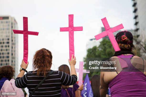 Demonstrators hold pink crosses representing the victims of femicide during a national strike on International Women's Day in Mexico City, Mexico, on...