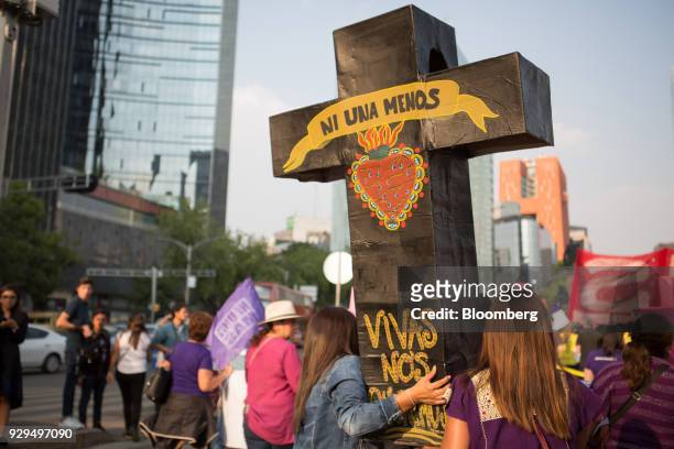 Demonstrator holds a cross that reads "Not one less" during a national strike on International Women's Day in Mexico City, Mexico, on Thursday, March...