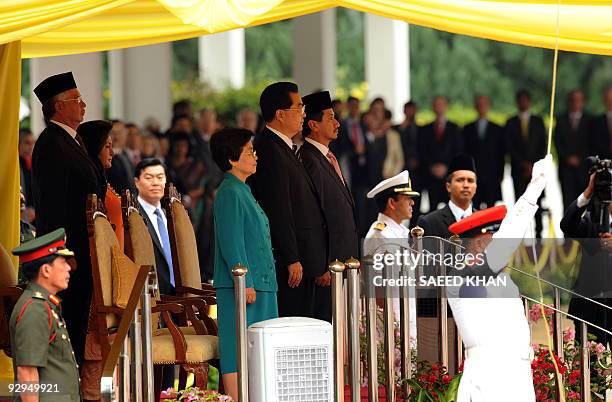 Chinese President Hu Jintao along with Malaysian King Tunku Mizan Zainal Abidin listens to the national anthem during a welcoming ceremony at the...