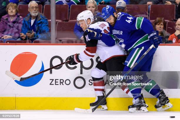 Arizona Coyotes Left Wing Max Domi is checked by Vancouver Canucks Defenceman Erik Gudbranson during their NHL game at Rogers Arena on March 7, 2018...