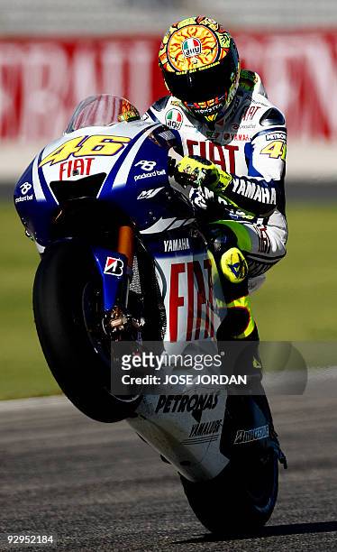 Yamaha's Italian rider Valentino Rossi does a wheelie during a practice session at the Ricardo Tormo racetrake in Cheste near Valencia, on November...