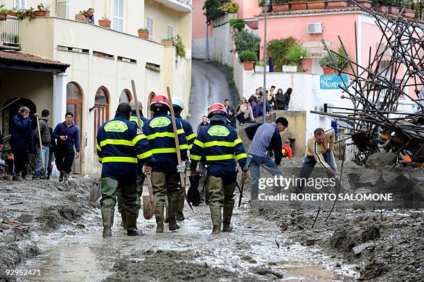 Rescuers walk in the mud after a mudslide on the southern Italian island of Ischia on November 10, 2009. A 15-year-old girl was killed and some...