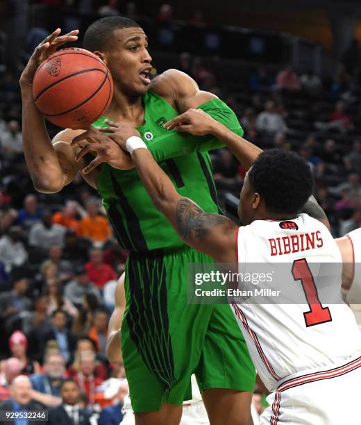 Justin Bibbins of the Utah Utes tries to steal the ball from Kenny Wooten of the Oregon Ducks during a quarterfinal game of the Pac-12 basketball...