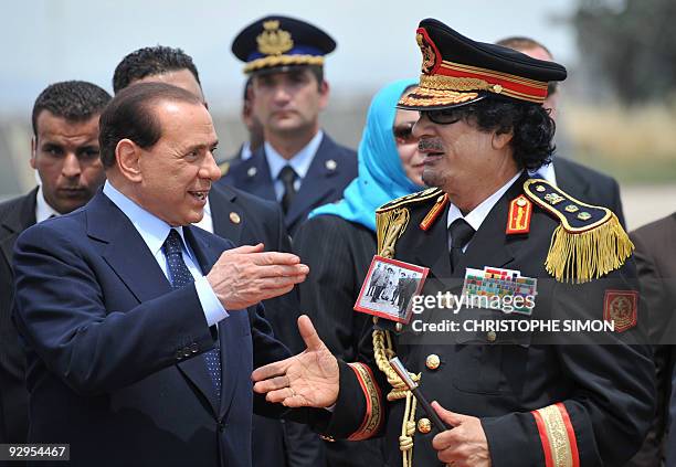 Libya's leader Moamer Kadhafi is greeted by Italian Prime Minister Silvio Berlusconi upon his arrival for his first visit to Italy on June 10, 2009...