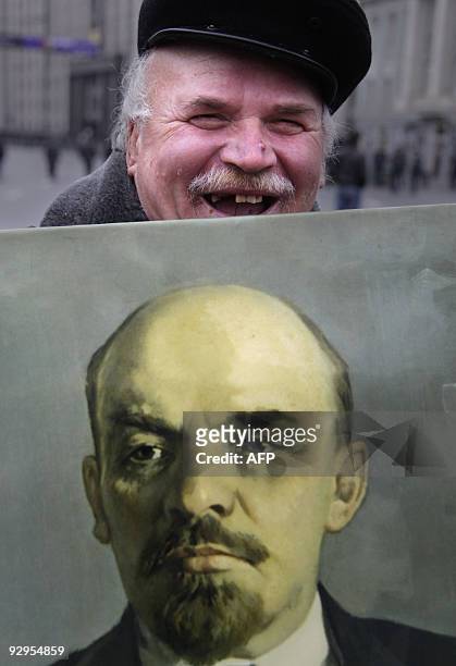 Russian Communist party supporter holds a portrait of Vladimir Lenin during a march in Moscow on November 7 marking the 92th anniversary of Vladimir...