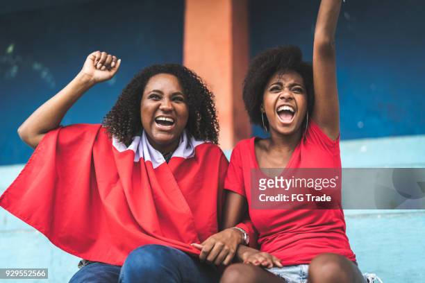 afro vrienden kijken naar een voetbalwedstrijd - costa rica women stockfoto's en -beelden