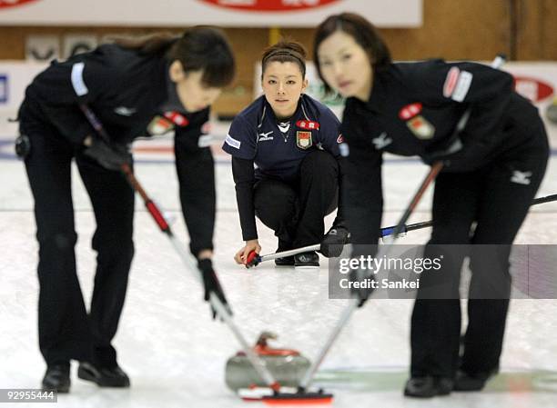 Mari Motohashi of Team Aomori has her stone swept by her teammates against Team Nagano during women's curling Vancouver Olympic qualifying at Aomori...