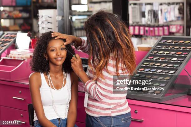 woman having makeup applied. - cosmetic testing store stock pictures, royalty-free photos & images