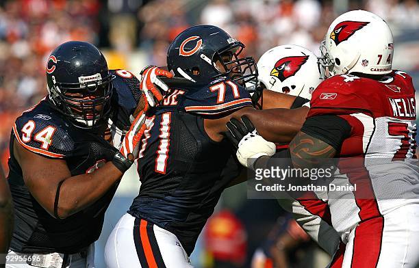 Israel Idonije of the Chicago Bears rushes against Reggie Wells and Lyle Sendlein of the Arizona Cardinals as teammate Marcus Harrison moves around...