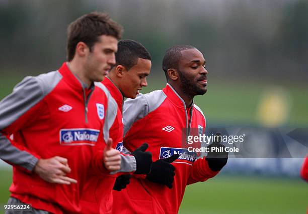 Darren Bent of England warms up with team mates Jermaine Jenas and Michael Carrick during a training session at London Colney on November 10, 2009 in...
