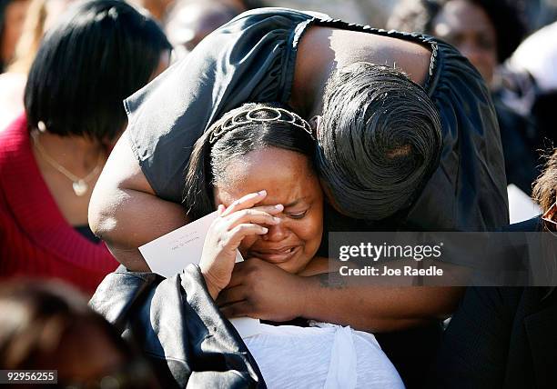 People grieve together before the start of the memorial service that U.S. President Barack Obama and first lady Michelle Obama will attend for the...