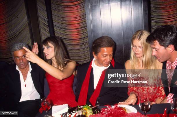 Italian fashion designer Valentino sits at a table with, from left, his business partner Giancarlo Giammetti, British actress and model Elizabeth...