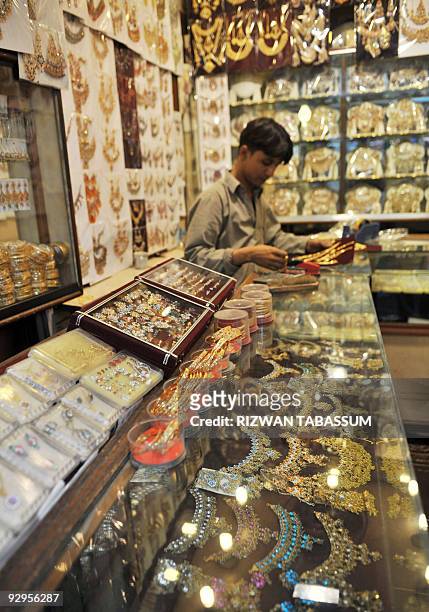 Pakistan-society-economy-weddings,FOCUS by Hasan Mansoor A Pakistani shop assistant arranges jewellery as he waits for customers at a shop in Karachi...