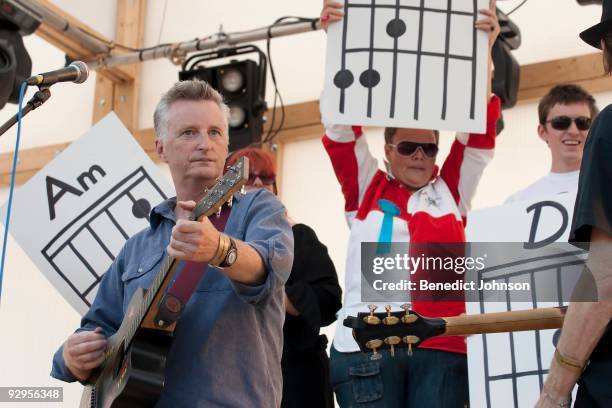 Billy Bragg and members of the audience holding up guitar chord diagrams perform on stage at the Village Green Festival on September 29th, 2009 in...