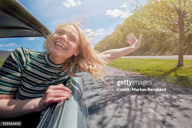 woman sticking head out of window while driving - buying a car stock pictures, royalty-free photos & images