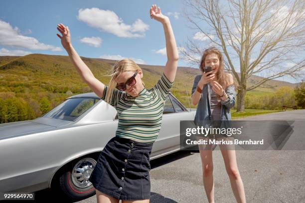 friends make pictures with cell phone - cool cars ストックフォトと画像