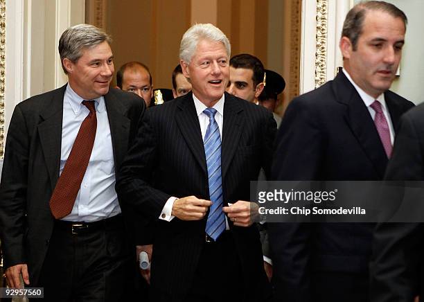 Former U.S. President Bill Clinton is accompanied by Sen. Sheldon Whitehouse as he heads into the Senate Democratic Caucus luncheon at the U.S....