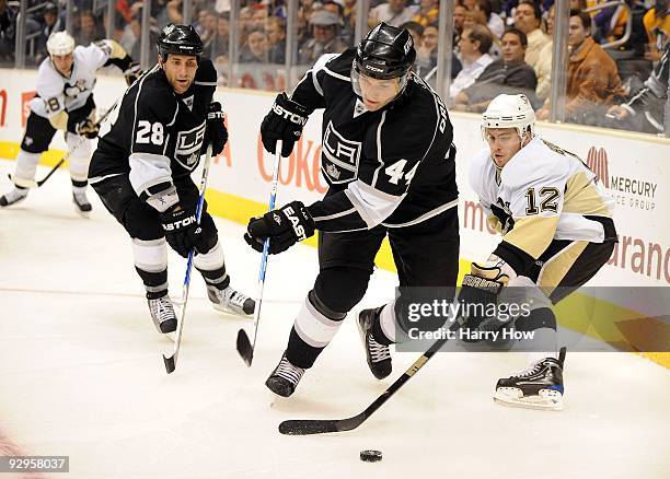 Christopher Bourque of the Pittsburgh Penguins attempts to poke the puck away from Davis Drewiske and Jarret Stoll of the Los Angeles Kings during...